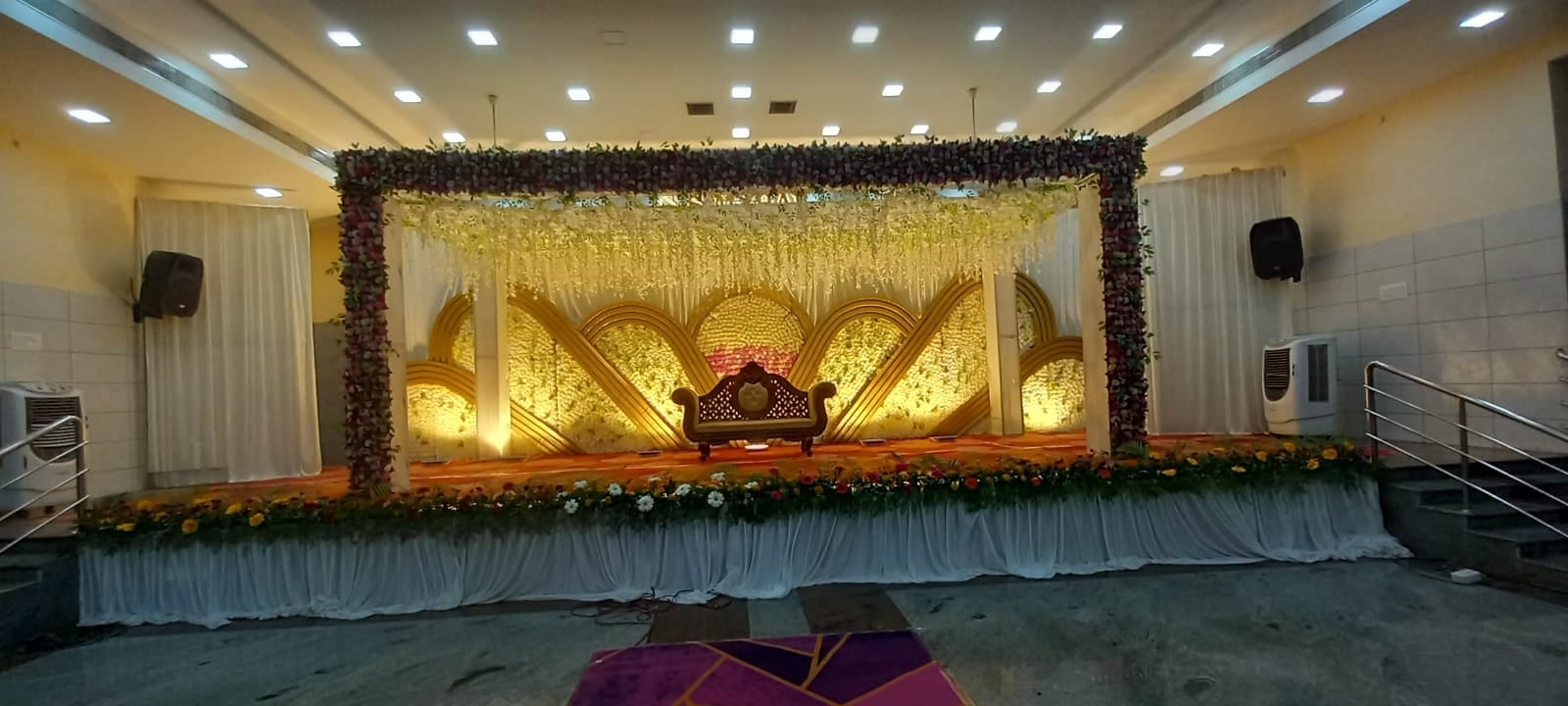 Golden wing-shaped stage backdrop with flowers